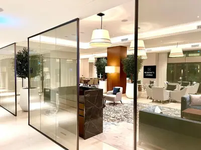 a lobby with glass walls and tables and chairs at The Address Residences Dubai Opera, Full Burj Khalifa View, 2BR Downtown Luxury in Dubai