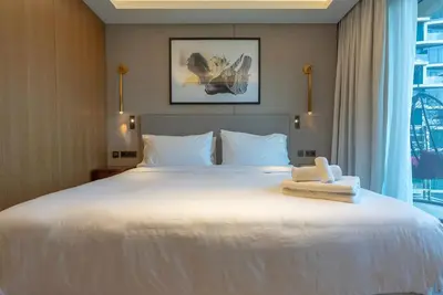 a bedroom with a large white bed with a window at The Address Residences Dubai Opera, Full Burj Khalifa View, 2BR Downtown Luxury in Dubai