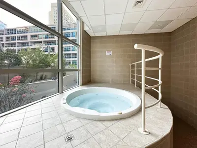 a hot tub in a room with a large window at 3-BDR Marina Gem w Stunning Yacht Bay Views in Dubai