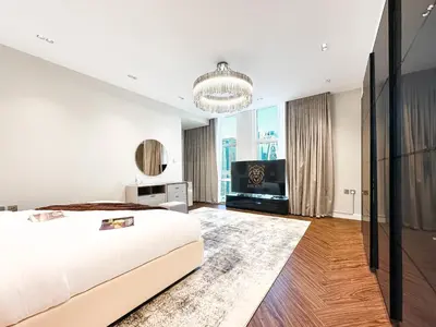 a bedroom with a bed and a flat screen tv at 3-BDR Marina Gem w Stunning Yacht Bay Views in Dubai