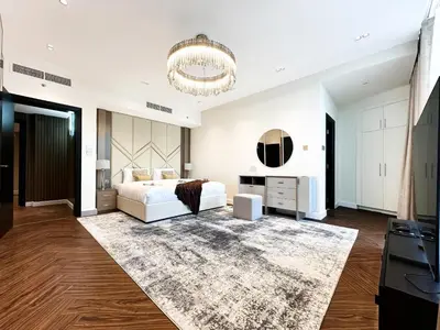 a bedroom with a white bed and a chandelier at 3-BDR Marina Gem w Stunning Yacht Bay Views in Dubai
