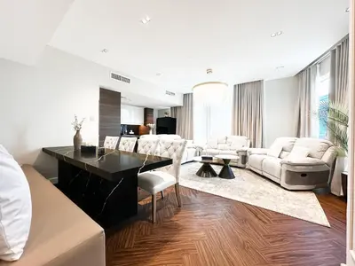 a living room with white furniture and a black table at 3-BDR Marina Gem w Stunning Yacht Bay Views in Dubai