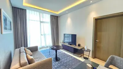 a living room with a couch and a television at Royalton - Damac Maison Prive in Dubai