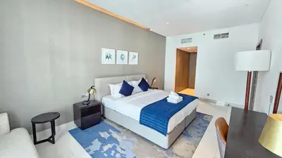 a bedroom with a bed and a table and a chair at Royalton - Damac Maison Prive in Dubai