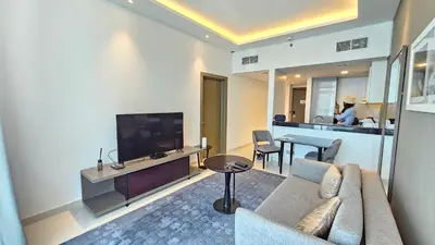 a living room with a couch and a flat screen tv at Royalton - Damac Maison Prive in Dubai