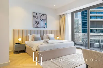 a bedroom with a large bed and a large window at LUX The Silverene Marina View Studio 1 in Dubai