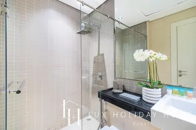 a bathroom with a sink and a glass shower at LUX The Silverene Marina View Studio 1 in Dubai