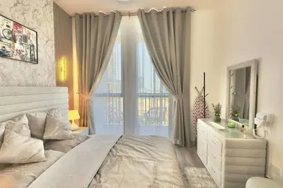 a bedroom with a large bed and a window at Elegant 1BR Midtown Near City Center Meaisem by Vibel in Dubai