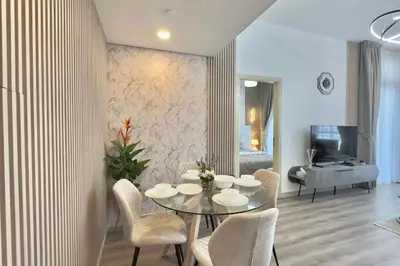 a living room with a table and chairs and a couch at Elegant 1BR Midtown Near City Center Meaisem by Vibel in Dubai
