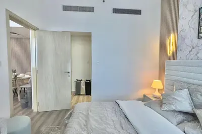a bedroom with a bed and a table and a desk at Elegant 1BR Midtown Near City Center Meaisem by Vibel in Dubai
