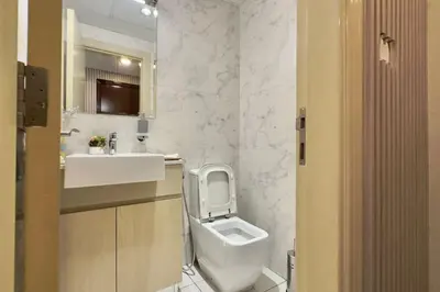 a bathroom with a toilet and a sink at Elegant 1BR Midtown Near City Center Meaisem by Vibel in Dubai