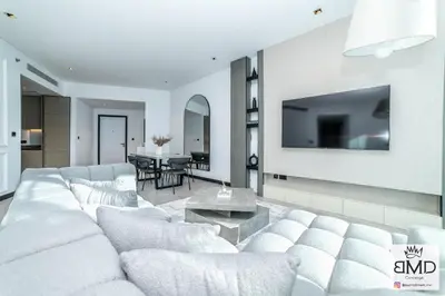 a living room with a white couch and a tv at Mordern Burj khalifa View 2bd in Dubai
