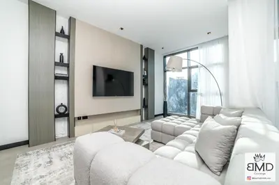 a living room with a white couch and a tv at Mordern Burj khalifa View 2bd in Dubai