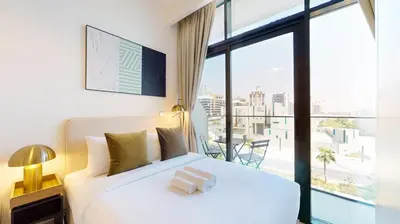 a bedroom with a white bed and a large window at Azizi Riviera 29 - Aesthetic Studio in Meydan in Dubai