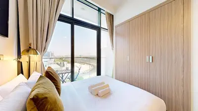 a bedroom with a bed with a large window at Azizi Riviera 29 - Aesthetic Studio in Meydan in Dubai