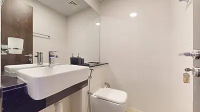a white bathroom with a sink and a toilet at Locations I Binghatti Gate I Premium Modern 2BR I Skyline & Community Views I Spacious & Comfortable Stay in Dubai