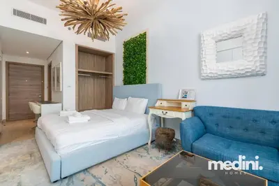 a bedroom with a bed and a blue couch at Studio One - Dubai Marina - Pool, Sauna, Hammam and Gym in Dubai