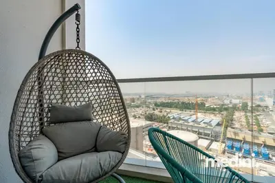 a hanging chair with a pillow in front of a window at Studio One - Dubai Marina - Pool, Sauna, Hammam and Gym in Dubai