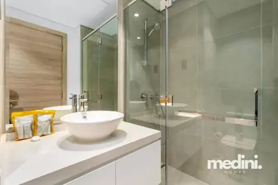 a bathroom with a sink and a glass shower at Studio One - Dubai Marina - Pool, Sauna, Hammam and Gym in Dubai