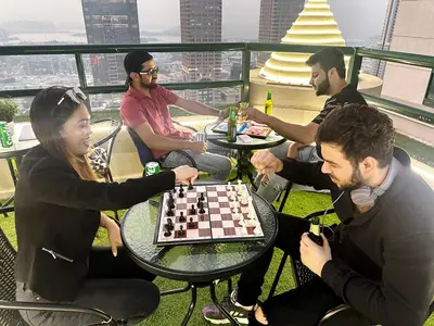 a group of people sitting around a table playing chess at Radiant Parition Room in Barsha Heights Near Metro in Dubai