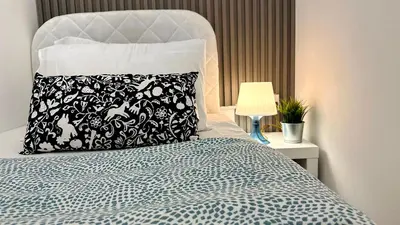 a bed with a black and white pillow and a lamp at Radiant Parition Room in Barsha Heights Near Metro in Dubai