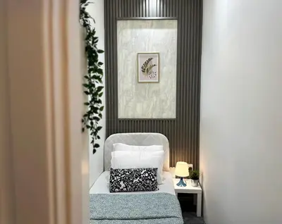a bedroom with a bed and a chair and a picture at Radiant Parition Room in Barsha Heights Near Metro in Dubai