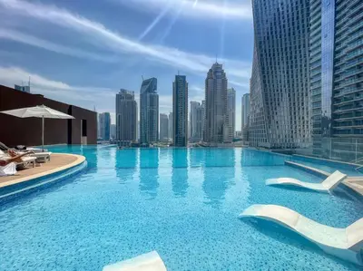 a large swimming pool with a city skyline at Dubai Marina 1BR with Pool Near Shops & Restaurants in Dubai