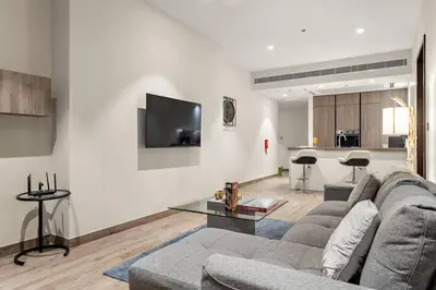 a living room with a couch and a tv on a wall at Dubai Marina 1BR with Pool Near Shops & Restaurants in Dubai