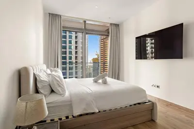 a bedroom with a bed and a large window at Dubai Marina 1BR with Pool Near Shops & Restaurants in Dubai