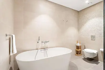 a white bath tub in a bathroom with a toilet at Dubai Marina 1BR with Pool Near Shops & Restaurants in Dubai