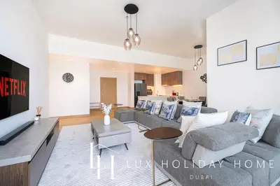 a living room with a couch and a tv at LUX The Elegant Sea View Suite in Dubai
