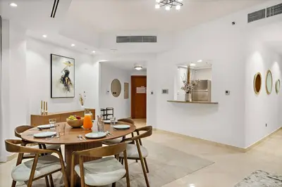 a dining room with a wooden table and chairs at FIRST CLASS 2BR Luxurious Escape in Dubai
