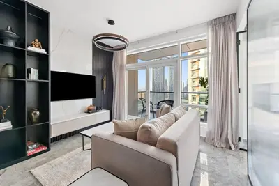 a living room with a couch and a large window at FIRST CLASS 2BR Premium City Escape in Dubai