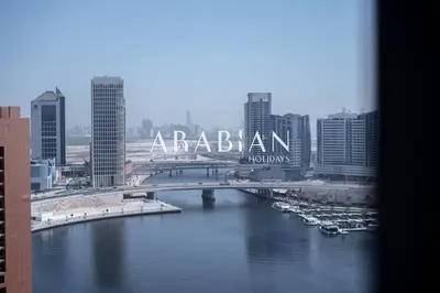 a view of a river with a bridge in a city at Cozy 1BR Apartment with Balcony in Business Bay in Dubai