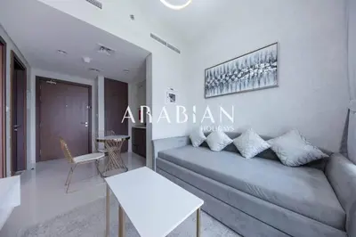 a living room with a couch and a table at Cozy 1BR Apartment with Balcony in Business Bay in Dubai
