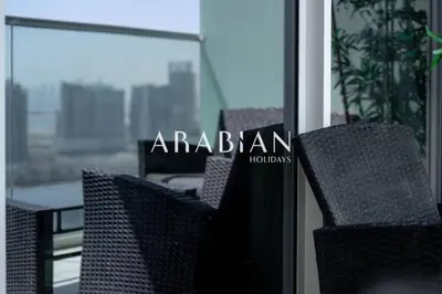 a couple of chairs sitting in front of a window at Cozy 1BR Apartment with Balcony in Business Bay in Dubai