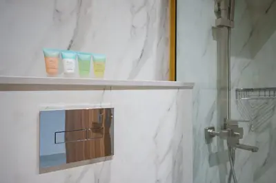 a bathroom with three bottles of moisturizers on a shelf at Stylish Studio Near Dubai Academic City in Dubai