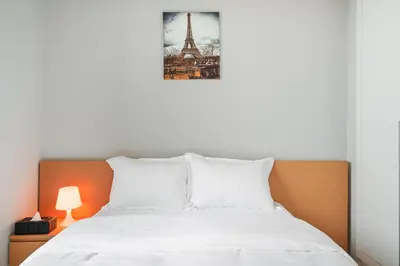 a bedroom with a bed and a picture of the eiffel tower at Stylish Studio Near Dubai Academic City in Dubai