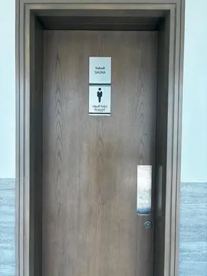 a door with a sign on it next to the ocean at Elevated Living at The Bay - Canal & Khalifa Views in Dubai