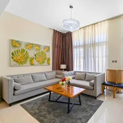 a living room with a couch and a table at Modern 3-Bedroom Villa in Damac Hills 2 in ‘Ūd al Bayḑāʼ