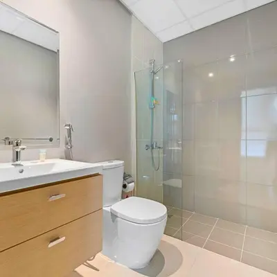 a bathroom with a toilet and a shower and a sink at Modern 3-Bedroom Villa in Damac Hills 2 in ‘Ūd al Bayḑāʼ