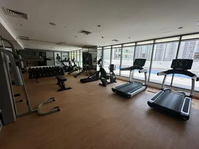 a gym with a bunch of treadmills and exercise bikes at Brand New JVC 1 bed - sleeps 4 in Dubai