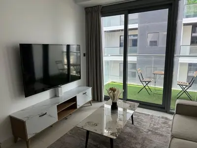 a living room with a television and a glass table at Brand New JVC 1 bed - sleeps 4 in Dubai