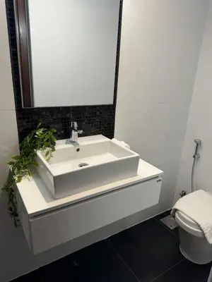 a bathroom with a white sink and a toilet at Brand New JVC 1 bed - sleeps 4 in Dubai