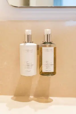 two bottles of soap sitting next to each other at Dubai Hills - 1BR Luxe Apartment - Golfville - by UDH in Dubai