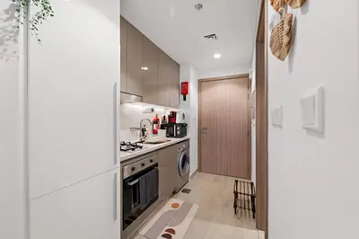 a kitchen with a stove and a dishwasher at Lovely Apt Near The Burj with Pool, Gym & BBQ Area in Dubai