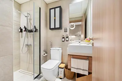 a bathroom with a toilet and a sink and a shower at Lovely Apt Near The Burj with Pool, Gym & BBQ Area in Dubai