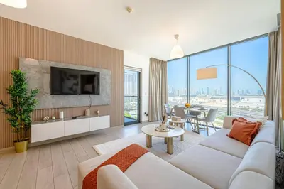 a living room with a white couch and a tv at Marco Polo - Experience luxury living with Burj Khalifa views in Dubai