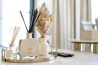 a glass table with two vases and flowers on it at Marco Polo - Experience luxury living with Burj Khalifa views in Dubai