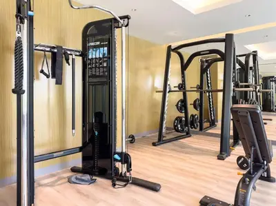 a gym with a row of treadmills and ellipticals at Marco Polo - Experience luxury living with Burj Khalifa views in Dubai